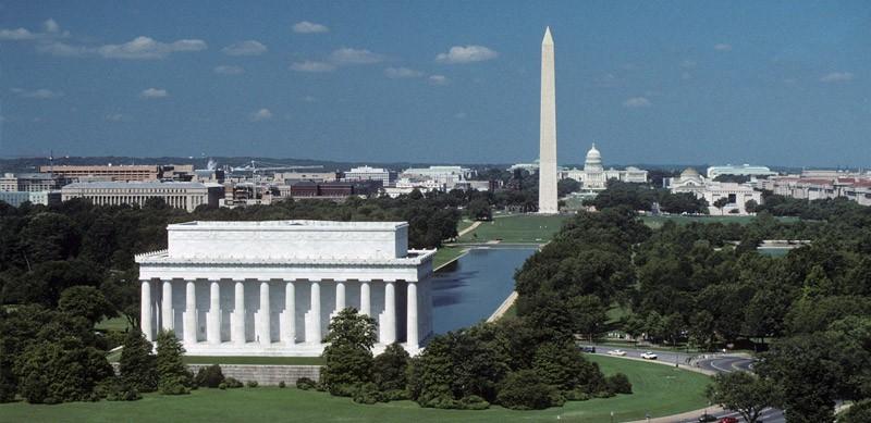 An aerial view of the mall in Washington DC from behind the Lincoln Memorial with the memorial in the foreground and the Washington Monument and Capitol Building in the background